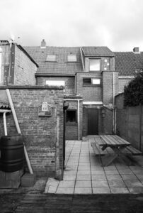 Dynamische renovatie van rijwoning met vlindervorming volume door architectenbureau Friday Office For Architecture. Bestaande toestand met typerende Vlaamse 'koterijen' in baksteen.