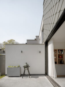 renovatie van een gezinswoning door friday office for architecture.De achtergevel op het gelijkvloers wordt compleet beglaasd, om de relatie met de tuin te vergroten. Op de verdieping blijft het volume gesloten. De nieuwe buitengevel werd geïsoleerd en afgewerkt met grijze leien. Een mooi leimotiv! Een groot schuifraam geeft uit op het terras buiten.