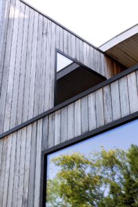 Een hedendaagse uitbouw met een elegante geste door Friday office for architecture. De volumetrie van deze uitbouw is groots en elegant. De detaillering en uitlijning van de hout- en glasvlakken zijn uitgekiend en in balans. Het niveauverschil tussen binnen en buiten wordt op een optimale manier uitgespeeld in het volume. Hierdoor ontstaat een subtiele opsplitsing van de zit- en eetruimte.