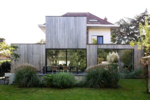 Een hedendaagse uitbouw met een elegante geste door Friday office for architecture. De volumetrie van deze uitbouw is groots en elegant. De detaillering en uitlijning van de hout- en glasvlakken zijn uitgekiend en in balans. Het niveauverschil tussen binnen en buiten wordt op een optimale manier uitgespeeld in het volume. Hierdoor ontstaat een subtiele opsplitsing van de zit- en eetruimte.