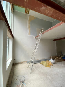renovatie van een gezinswoning door Friday office for architecture in Mortsel. Dit is een werffoto van de gelijkvloerse verdieping met zicht op de vide.
