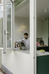 Verbouwing van een gezinswoning in Berchem door friday office for architecture. In de woning werd een nieuwe keuken voorzien met donkergroen maatwerk. De keuken is voorzien van een groot vouwraam- en deur waardoor de keuken rechtstreeks in contact komt met de tuin.